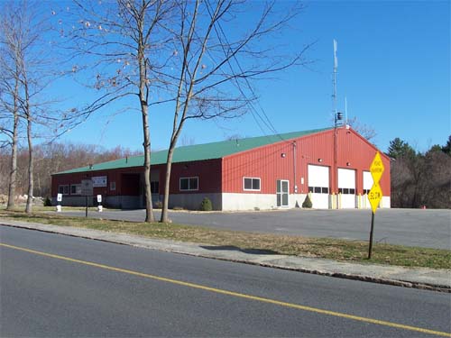 Village of Manchaug - photo of station #2 taken from road - showing 3 large wide and tall &quot;garage&quot; doors on side